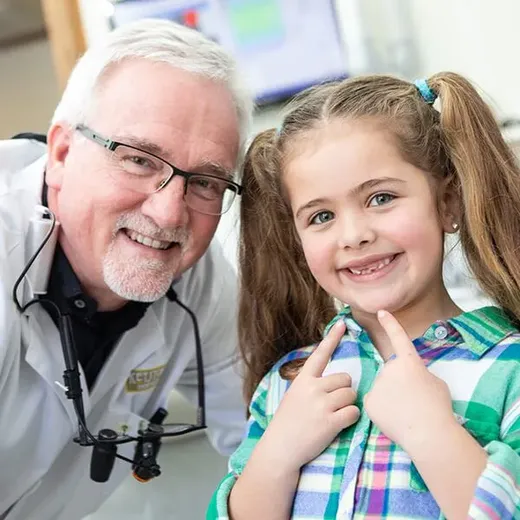 Dr. Kinney sharing a laugh with a young patient in the exam chair