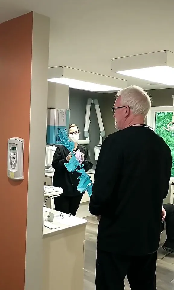 Dr. Kinney discovering a chain of knotted gloves pulled from the dispenser, from a video on our Facebook page